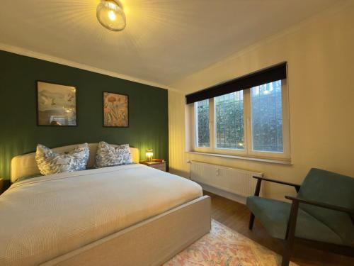 ein Schlafzimmer mit einem großen Bett und einem Fenster in der Unterkunft The Forest Green Residence with Garden & Tranquility in Oldenburg