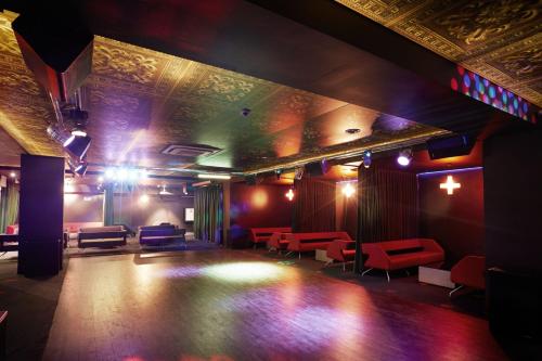 a room with a stage with red and blue chairs at Marine Hotel by Zdrojowa in Kołobrzeg