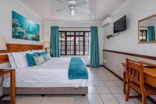 a bedroom with a large bed and a television at Lodge At The Link in Kempton Park