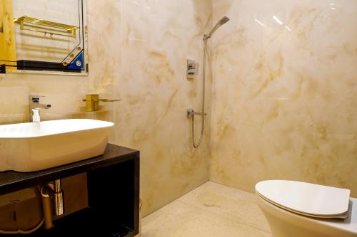 a bathroom with a sink and a toilet and a shower at NTS Nirvana Suites in Bangalore
