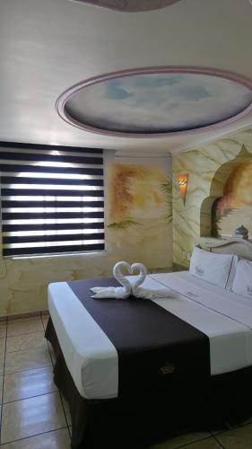 a bedroom with a bed with a white ribbon on it at Motel Harem in Guadalajara