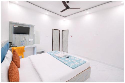 een witte kamer met een bed en een tv bij Vrinda Home-Stay Near Vishwanath Temple - Free Wifi and Free Parking Facilities # Free Wifi Facilities # Fully Air conditioning Luxuary Room - Top Rated Hotel In Varanasi in Varanasi