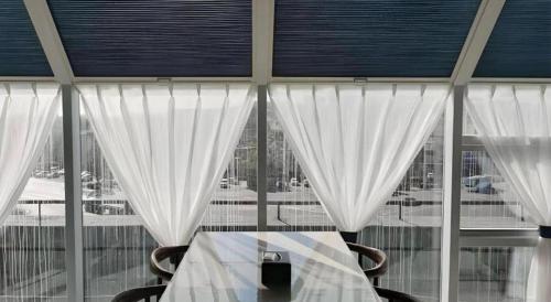 a room with a table and a window with curtains at GreenTree Inn Express Liaoning Jinzhou Bijia Mountain in Dandong