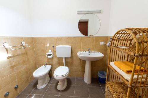 a bathroom with a toilet and a sink and a mirror at Casa Schmidt in Vulcano