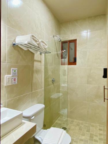a bathroom with a shower with a toilet and a sink at Hotel Santa Cruz Mazunte in Mazunte
