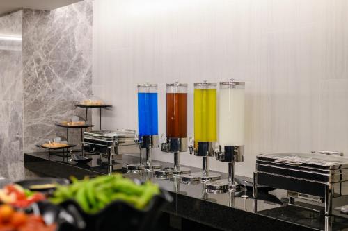 een rij kleurrijke glazen op een toonbank bij Marquis Hotel in Ban Bang Toei (1)