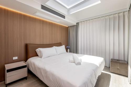 een slaapkamer met een groot wit bed en een raam bij Aravina Escapes in Yallingup Siding