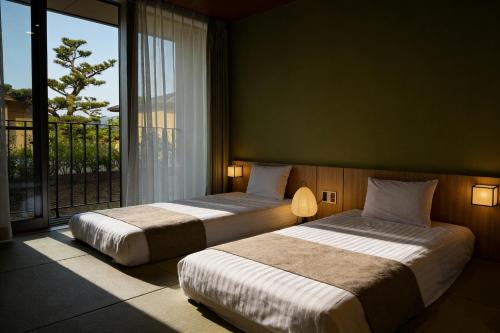 Postel nebo postele na pokoji v ubytování Kansai Airport Hotel Pine Villa