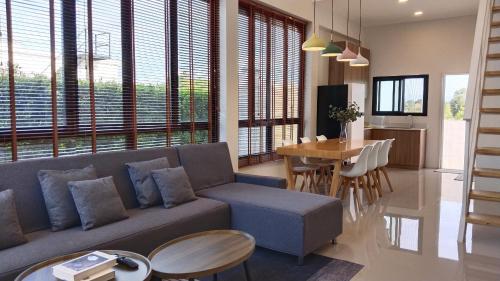 een woonkamer met een bank en een tafel bij THE HOLM At Khaoyai in Pak Chong