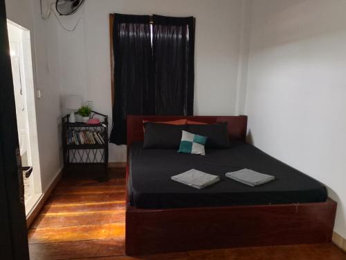 a bedroom with a bed with two towels on it at The Picture House M'Pai Bay in Kaôh Kon