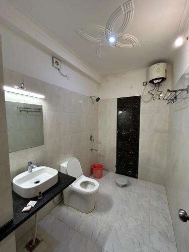 a bathroom with a toilet and a sink and a mirror at Hotel Giriraj Palace in Jaipur
