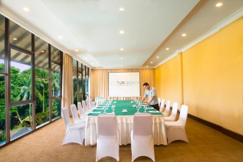 a man standing in a large room with a long table at Turi Beach Resort in Nongsa