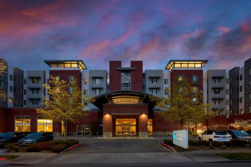 a building with cars parked in a parking lot at Hyatt House Seattle Bellevue in Bellevue
