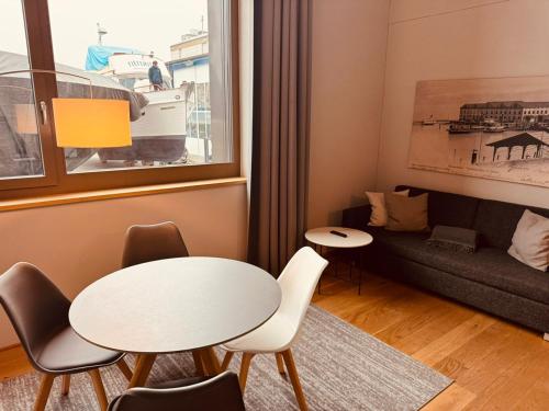 un salon avec une table, des chaises et un canapé dans l'établissement LAKE-SIDE Säntisblick, à Romanshorn