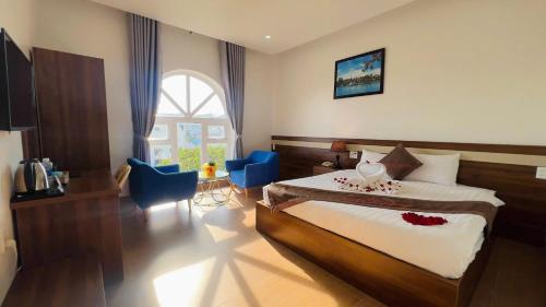 a bedroom with a bed and two blue chairs at Anh Duc Hotel Da Lat in Da Lat