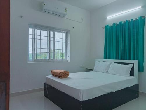 a bedroom with a bed with a green curtain at Dream stay villaa in Pondicherry