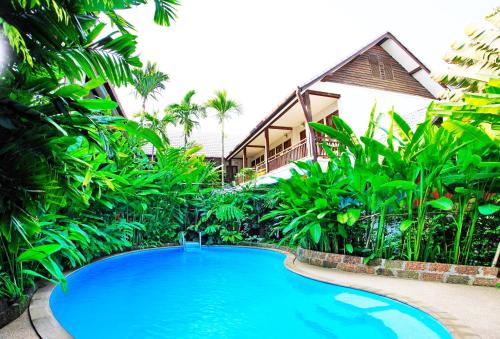a large blue swimming pool in front of a building at Shewe Wana Boutique Hotel in Chiang Mai