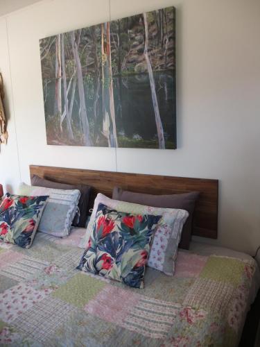 a bedroom with two beds and a painting on the wall at Little Birdy in Tawonga