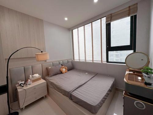ein kleines Schlafzimmer mit einem Bett und einem Fenster in der Unterkunft Căn hộ cao cấp Nera Garden in Hue