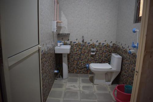 ein Badezimmer mit Toilette und Waschbecken in der Unterkunft The Kalp in Jāmb