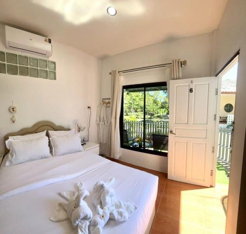 a bedroom with a bed with two stuffed animals on it at Yada House Alina Cottage in Nai Yang Beach