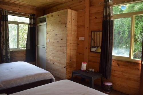 ein Schlafzimmer mit zwei Betten und zwei Fenstern in der Unterkunft The Kalp in Jāmb