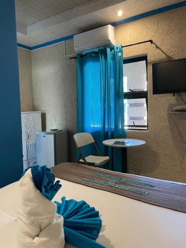 ein Zimmer mit einem Bett und einem blauen Vorhang in der Unterkunft Ngami Gates Boutiqúe Guesthouse in Maun