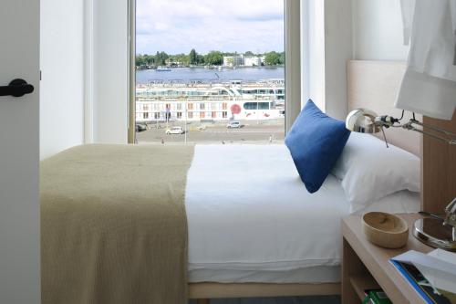 a bedroom with a bed with a view of a harbor at Eric Vökel Boutique Apartments - Amsterdam Suites in Amsterdam