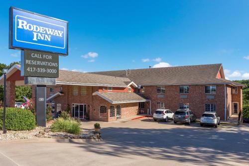 a hotel with a sign in front of a building at Rodeway Inn Branson, Brick House in Branson