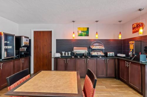 a kitchen with a wooden table and a counter top at Quality Inn - Norman near University in Norman