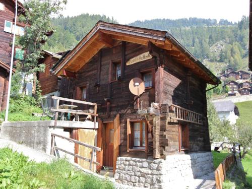 a log cabin on a hillside with a porch at wooden chalet in Betten near the Aletsch Arena in Betten