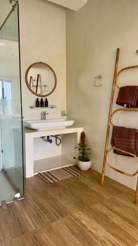 a bathroom with a sink and a mirror at Calma Cafe - Surf, Stay and Yoga in Dickwella