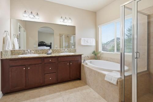 une salle de bain avec une baignoire, un lavabo et une douche dans l'établissement Casa Cortez, à Visalia