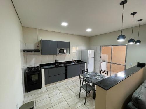 een keuken met een tafel en een aanrechtblad bij Casa de alto padrão in Aparecida