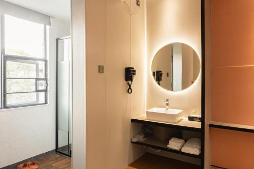 a bathroom with a sink and a mirror at Youth Innovation Apartment in Guangzhou