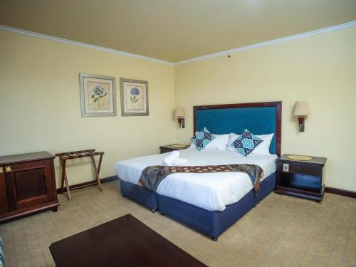 een hotelkamer met een groot bed en twee tafels bij Carousel Eco Estate in Temba