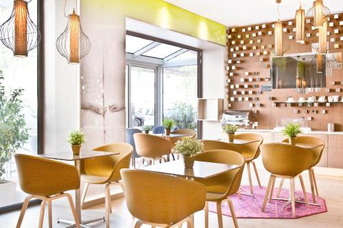 a restaurant with tables and chairs in a room at Hotel Eiffel Segur in Paris