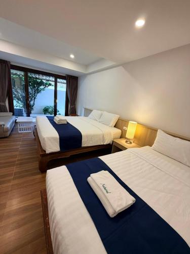 a hotel room with two beds and a window at Natural Samui Hotel in Bophut