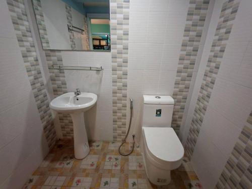 a bathroom with a toilet and a sink at Dee-maak Hostel in Thongsala