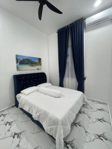 a bedroom with a bed and a ceiling fan at Farisya Homestay in Kota Bharu