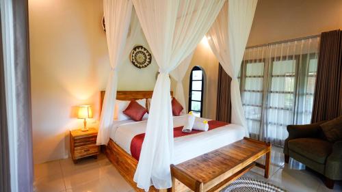 a bedroom with a bed with a canopy at D'Penglipuran Jungle House in Susut