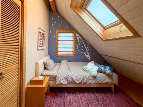 a small bedroom with a bed and a window at yado suzuka 1 in Suzuka