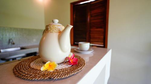 a vase sitting on a table with flowers on it at D'Penglipuran Jungle House in Susut