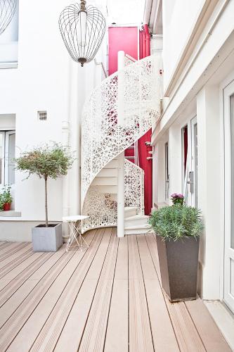 a white staircase in a building with potted plants at Hotel Eiffel Segur in Paris