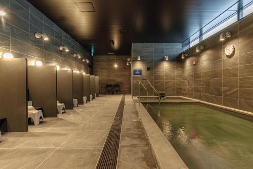 a bath room with a pool of water in a bathroom at Setouchi Cycle Stays Hiroshima Ujina in Hiroshima