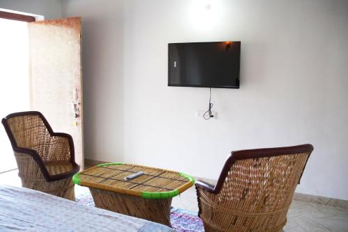 a room with two chairs and a table and a tv at Narayani Bag Resort & Restaurant 