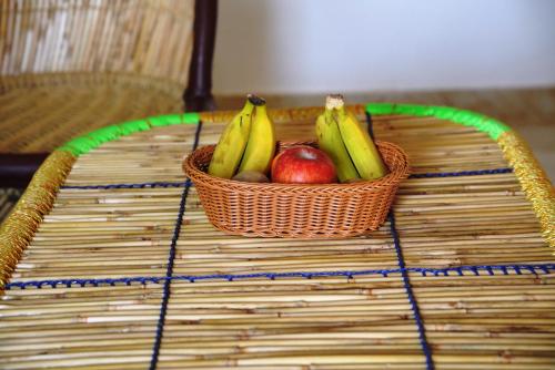 a basket of bananas and apples on a table at Narayani Bag Resort & Restaurant 