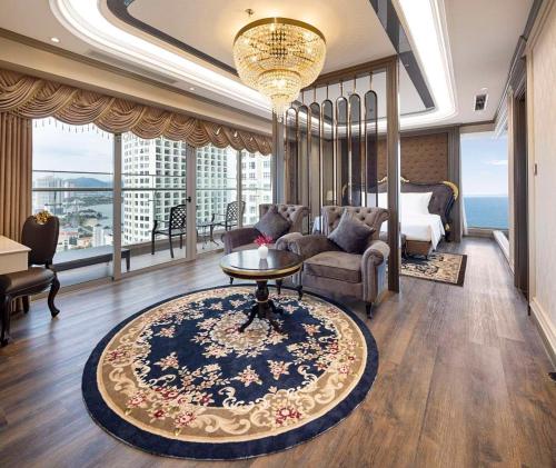 a bedroom with a bed and a living room with a table at Annova Nha Trang Hotel in Nha Trang