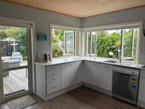 eine Küche mit Spüle und Fenster in der Unterkunft Graydon Grove in Kaiteriteri