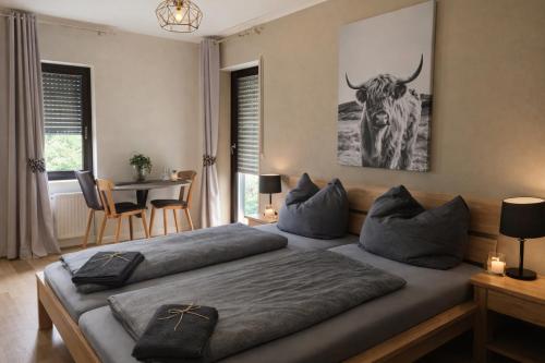 une chambre avec un lit avec un taureau sur le mur dans l'établissement Pension zur Quelle, à Deudesfeld